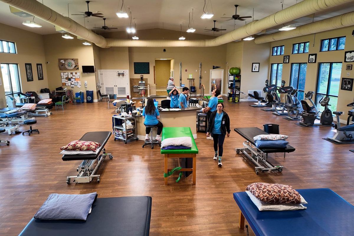 The rehab gym at Castroville Physical Therapy with treatment tables, therapists and open floor space